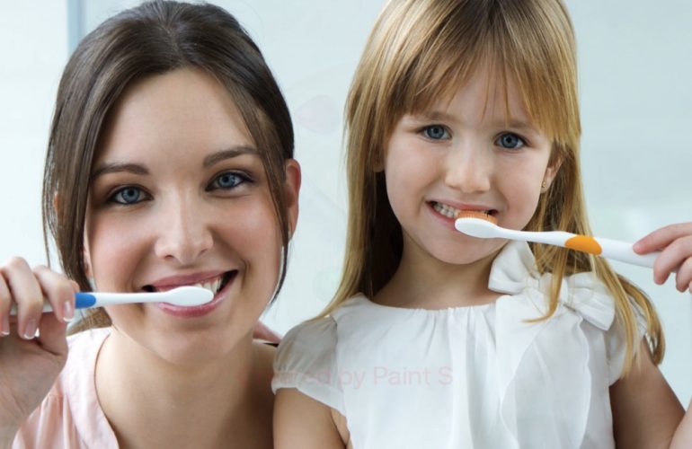 madre e hija cepillándose los dientes para evitar las enfermedades bucodentales más comunes en niños