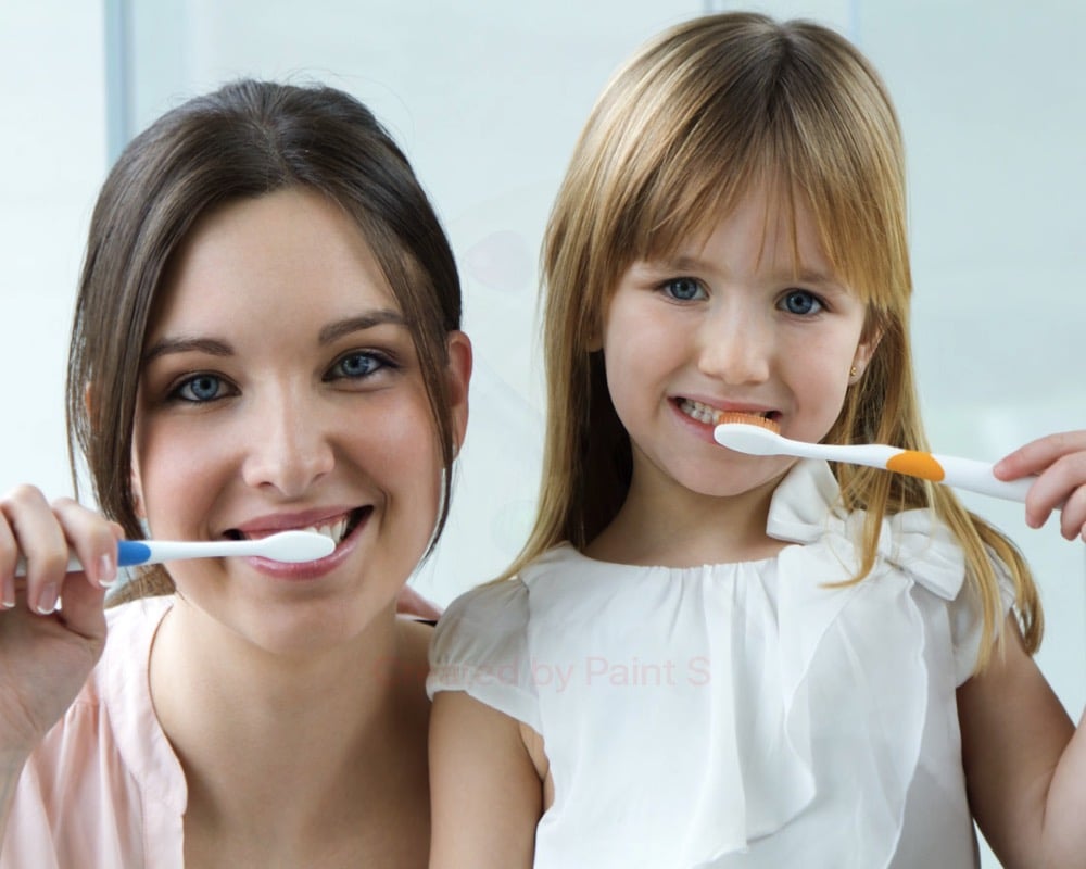 madre e hija cepillándose los dientes para evitar las enfermedades bucodentales más comunes en niños