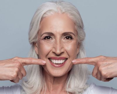 mujer con pr&oacute;tesis dentales en al boca